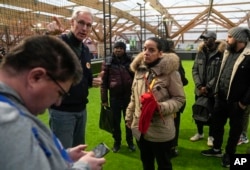 Stephane Lange, left, of Pole Emploi gestures as he guides a job seeker during an Olympics jobs fair in Paris on Dec. 14, 2023.