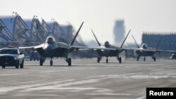 지난해 12월 한국 군산공군기지에서 미한연합훈련에 참가한 미 공군 F-22 전투기들이 이륙하고 있다.