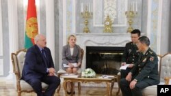 In this handout photo released by the Belarusian Presidential Press Office, Belarusian President Alexander Lukashenko, left, and China's Defense Minister Gen. Li Shangfu, right, speak during their talks in Minsk, Belarus, Aug. 17, 2023. 