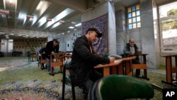 Voters fill out their ballots during elections at a polling station in Tehran, Iran, March 1, 2024. It was the country's first poll since mass protests in 2022 over mandatory hijab laws after the death in police custody of Mahsa Amini.
