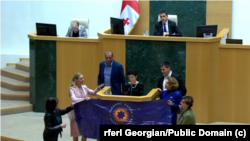 საქართვეოს პარლამენტი - დეპუტატმა ქალებმა კულტურის მინისტრის გამოსვლისას გაშალეს ბანერი უკრაინელი სამხედროს ცნობილი ფრაზით.