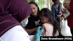 Two-year-old Alicia Musa gets vaccinated for measles and rubella at a public health clinic in Taguig, Philippines, May 18, 2023.