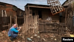 Andrew Harper, climate advisor for the UN refugee agency known as UNHCR, photographs a house partially destroyed by the floods that hit Porto Alegre, in the state of Rio Grande do Sul, Brazil, June 23, 2024.