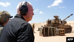 Menteri Pertahanan Israel Yoav Gallant berdiri bersama tentara di dekat howitzer artileri di sepanjang perbatasan dengan Jalur Gaza di Israel selatan dekat Rafah, 7 Mei 2024. (Foto: AFP)