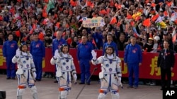Chinese astronauts for the Shenzhou-18 mission, from left, Li Guangsu, Li Cong and Ye Guangfu, wave as they attend a send-off ceremony for their manned space mission at the Jiuquan Satellite Launch Center in northwestern China, April 25, 2024. 
