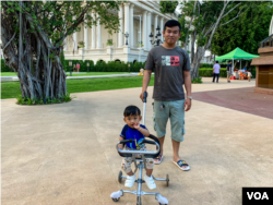 លោក ឡុង ពុធដាណូ ពលរដ្ឋរស់នៅក្នុងរាជធានីភ្នំពេញ កំពុងរុញកូនដើរកម្សាន្តនៅសួនមួយកន្លែងក្នុងបុរីប៉េងហួត នៅសង្កាត់និរោធ ខណ្ឌច្បារអំពៅ នៅថ្ងៃទី១៨ ខែកុម្ភៈ ឆ្នាំ២០២៣។ (កាន់ វិច្ឆិកា/វីអូអេ)