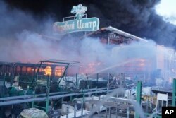Petugas pemadam kebakaran memadamkan api setelah dua bom menghantam toko perlengkapan konstruksi besar di Kharkiv, Ukraina, 25 Mei 2024. Tulisan bertuliskan "Garden Center." (Foto: AP)
