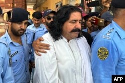 Petugas polisi menghadirkan politisi yang ditangkap Ali Wazir (tengah) di hadapan pengadilan di Islamabad pada 20 Agustus 2023. (Foto: AFP)