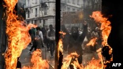 A protestor holds a sign reading 'Shoked by burnt plastic but not by our stolen pensions' during a demonstration on May Day (Labour Day) to mark the international day of the workers, in Lyon, eastern France, on May 1, 2023. 