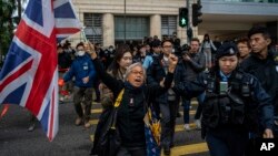 Activist Alexandra Wong, also known as Grandma Wong, holds a flag of Britain outside West Kowloon Magistrates' Courts, where activist publisher Jimmy Lai's trial is scheduled to open, in Hong Kong, Monday, Dec. 18, 2023. (AP Photo/Vernon Yuen)