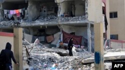 22일 가자지구 남부 라파에 이스라엘의 군 작전으로 무너진 건물 잔해 사이를 팔레스타인 주민들이 걷고 있다.