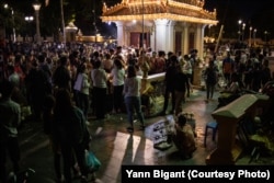 អ្នកលក់ចាបអង្គុយចាំអតិថិជនដែលមកបន់ស្រន់នៅ ព្រះអង្គដងកើក្នុងរាជធានីភ្នំពេញ។ (រូបផ្តល់ឱ្យដោយលោក Yann Bigant)