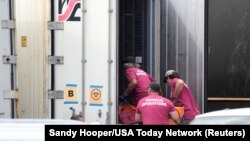 เจ้าหน้าที่ห้องเก็บศพเร่งน้ำร่างเหยื่อไฟป่าเกาะเมาวีเข้าไปเก็บในตู้เย็นคอนเทนเนอร์ ที่สำนักงานนิติวิทยาเขตเมาวีเคาน์ตี้ รัฐฮาวาย เมื่อวันที่ 15 ส.ค. 2023. 