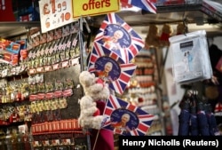 Warga melihat-lihat kios suvenir yang memajang cendera mata yang dirancang untuk Penobatan Raja Charles III di London, Inggris, 14 April 2023. (Foto: REUTERS/Henry Nicholls)