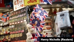 Warga melihat-lihat kios suvenir yang memajang cendera mata yang dirancang untuk Penobatan Raja Charles III di London, Inggris, 14 April 2023. (Foto: REUTERS/Henry Nicholls)