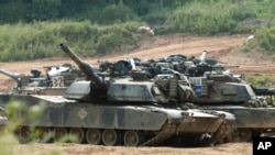 FILE - US M1A1 Abrams tanks block a path at a training range in Paju, near Demilitarized Zone (DMZ), 50 kilometer north of Seoul, on June 9, 2003. 
