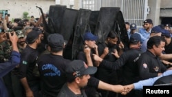 Private security guards escort Pakistan's former Prime Minister Imran Khan as he leaves after he appeared at the High Court in Islamabad, May 31, 2023. 