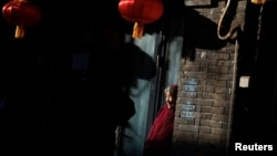 រូបឯកសារ៖ ពលរដ្ឋចិនវ័យចំណាស់ម្នាក់ឈរនៅ​មុខគេហដ្ឋានមួយ នៅទីក្រុងប៉េកាំង ប្រទេសចិន កាលពីថ្ងៃទី១៥ ខែមករា ឆ្នាំ២០២៣។ 