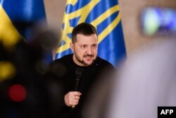 Reaksi Presiden Ukraina Volodymyr Zelensky saat sesi tanya jawab dengan perwakilan media internasional di Museum Sejarah Nasional Latvia pada 11 Januari 2024 di Riga, Latvia. (Foto: AFP)