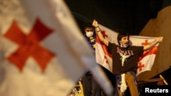 A protester carries a Georgian flag during a rally to protest against a bill about "foreign agents" in Tbilisi, Georgia, May 2, 2024.