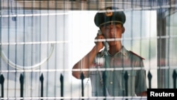 រូបឯកសារ៖ មន្ត្រីល្បាតម្នាក់និយាយទូរសព្ទនៅក្បែរស្ថានទូតសហរដ្ឋអាមេរិកនៅក្នុងទីក្រុងប៉េកាំង ប្រទេសចិន កាលពីថ្ងៃទី ២៦ ខែកក្កដា ឆ្នាំ ២០១៨។ 