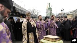 Priests of Ukrainian Orthodox Church pray with their supporters after resisting a government order to leave the Kyiv Pechersk Lavra monastery complex in Kyiv, on April 1, 2023. (Roman Hrytsyna/AP)