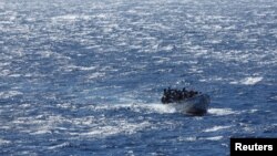 FILE - Migrants arrive on a wooden boat near the port of La Restinga on the Canary Island of El Hierro, Spain, Nov. 9, 2023. 
