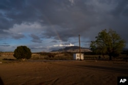A rainbow is seen in the distance from the closed Chilchinbeto Church of the Nazarene in Chilchinbeto, Arizona, on the Navajo reservation, April 21, 2020. About 40,000 homes in Indian Country in Arizona don't have traditional addresses.
