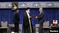 Iran's Supreme Leader Ayatollah Ali Khamenei gives a Presidential decree to Iran's new president, Masoud Pezeshkian, during an endorsement ceremony in Tehran, July 28, 2024. (Office of the Iranian Supreme Leader/WANA/Handout via Reuters) 