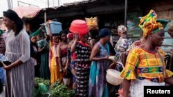 FILE - Women shop at a street market in Banjul, Gambia, Dec. 3, 2021. The country may soon reverse its ban on female genital mutilation, a practice that has been on the rise worldwide in recent years despite moves to outlaw it.