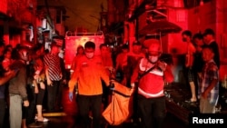 Tim penyelamat membawa kantong jenazah korban setelah kebakaran di stasiun penyimpanan bahan bakar yang dioperasikan oleh Pertamina, di Plumpang, Jakarta, 3 Maret 2023. (REUTERS/Willy Kurniawan)