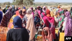 FILE - Refugees fleeing the conflict in Sudan queue with their jerrycans to collect drinking water from the Doctors Without Borders (MSF) distribution point at the Ourang refugee camp in Adre, Chad, on Dec. 7, 2023. 