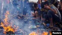 Sejumlah warga Palestina berusaha mencari makanan yang tersisa di antara puing-puing menyusul serangan Israel ke kamp pengungsi di Rafah, di selatan Jalur Gaza, pada 27 Mei 2024. (Foto: Reuters/Mohammed Salem)