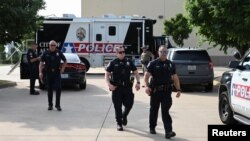 Officers with the Allen Police Department are seen at a mobile command post a day after a gunman shot multiple people at the Dallas-area Allen Premium Outlets mall in Allen, Texas, May 7, 2023.