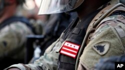 FILE - A solider from the District of Columbia National Guard watches as demonstrators gather to protest the death of George Floyd, June 3, 2020, near the White House in Washington. 