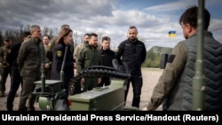 FILE - Ukraine's President Volodymyr Zelenskyy inspects samples of military equipment and weapons in the Kyiv region of Ukraine, April 13, 2024. On Sunday, he will visit a U.S. ammunition factory producing munitions Ukraine is using to fight Russian ground forces. 