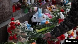 ประชาชนในรัสเซียร่วมกันวางดอกไม้ที่อนุสรณ์ชั่วคราวสำหรับเหยื่อเหตุยิงกราดที่สถานที่จัดคอนเสิร์ตชานกรุงมอสโก ที่นครเซนต์ปีเตอร์สเบิร์ก เมื่อ 24 มี.ค. 2567