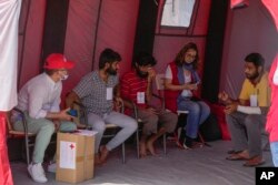 ڈوبنے والے جہاز کے زندہ بچ جانے والے ریڈ کراس کے رضاکاروں سے بات کر رہے فوٹو اے پی ، 15 جون 2023