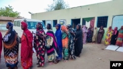 FILE - Internally displaced women wait to collect aid from a group at a camp in Gadaref on May 12, 2024, while clashes reignited between the Sudanese army and rival paramilitaries in the key Darfur town of El Fasher.