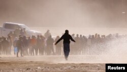 Migrants stand near the border wall after crossing the Rio Bravo river with the intention of turning themselves in to the U.S. Border Patrol agents, as seen from Ciudad Juarez, Mexico, April 25, 2023.