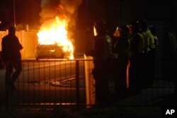 A police car burns as officers are deployed on the streets of Hartlepool, England, on July 31, 2024, following a violent protest in the wake of the killing of three girls who were fatally stabbed in northwest England.