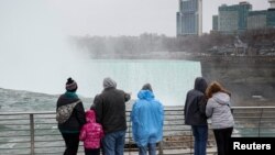 Sejumlah wisatawan melihat ke arah air terjun Horseshoe di area air terjun Niagara, New York, menjelang gerhana matahari total, pada 5 April 2024. (Foto: Reuters/Brendan McDermid)