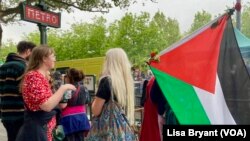 A protester holds a Palestinian flag and the traditional May Day bouquet at the Place de la Republique in Paris.