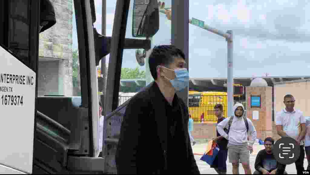 从大巴上下来的中国面孔的移民。