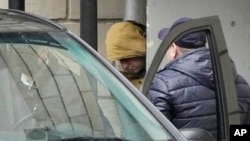FILE - Wall Street Journal reporter Evan Gershkovich is escorted by security officers from the Lefortovsky Court to a minivan, in Moscow, March 30, 2023.