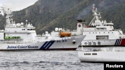 A China Coast Guard vessel sails near a Japan Coast Guard vessel Kabira off Uotsuri Island, one of a group of disputed islands called Senkaku Islands, also known in China as Diaoyu Islands, in the East China Sea, Apr. 27, 2024. (Kyodo/via Reuters) 