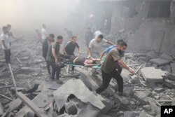 Palestinians evacuate wounded people after an Israeli airstrike in Rafah refugee camp, southern Gaza Strip, Oct. 12, 2023.