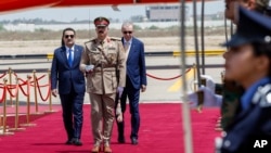 Iraqi Prime Minister Mohammed Shia al-Sudani, left, and Turkish President Recep Tayyip Erdogan, right, attend a welcoming ceremony at Baghdad International Airport, April 22, 2024. (Pool/AP)