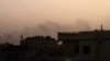 Smoke billows behind buildings in southern Khartoum, on May 27, 2023, amid ongoing fighting between the forces of two rival generals.