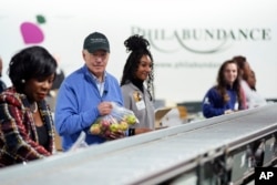 President Joe Biden volunteers at Philabundance, a hunger relief organization, to mark Martin Luther King Jr. day, in Philadelphia, Jan. 15, 2024.